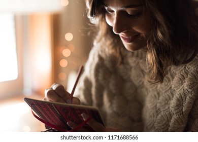 Young woman writing on a sketchbook