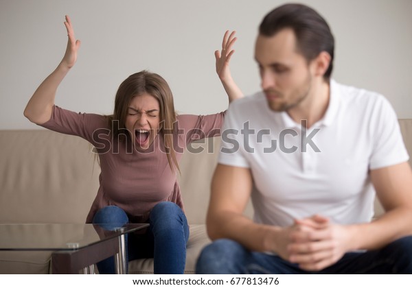 Young woman yelling at boyfriend in\
hysterics, drama queen screaming loud shouting at husband trying to\
get attention, having a tantrum, lack of emotional intelligence,\
manipulation in\
relationships