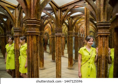 Young Woman In Yellow Dress In Big Mirror Room.