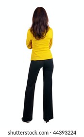 Young woman in yellow suit looking at wall. The rear view.