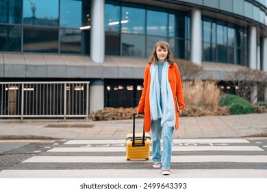 Young Woman With Yellow Suitcase Crosses Street in Urban Area on Bright Day - Powered by Shutterstock