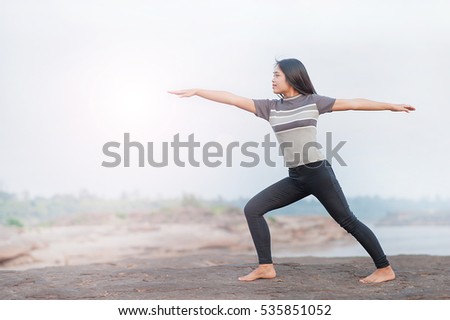 Young woman with yoga position at the mountain