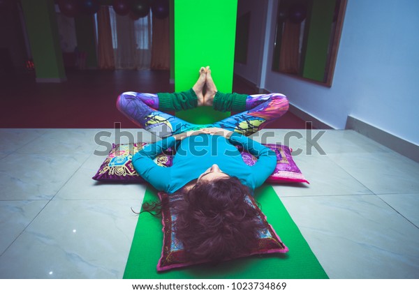 young woman in yoga relaxing pose with legs up the\
wall full body shot