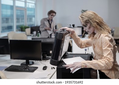 Young Woman With Zombie Greasepaint On Face And Hands Standing By Xerox Machine And Opening Lid