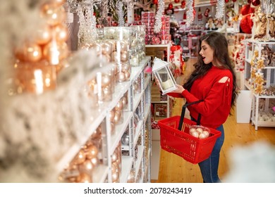 Young Womanholding Lantern Inside Christmas Ornament Store, Shopping For Decoration For Her Home 