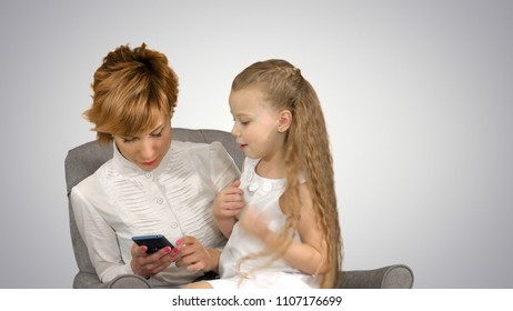 Young woman-mother and child look in phone on white background