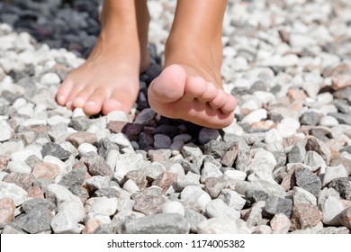 Young woman's barefoot walking on the small stones in sunny summer day.  - Shutterstock ID 1174005382