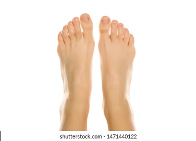Young woman's beautiful bare feet and toes top view. Closeup isolated on white background. 
