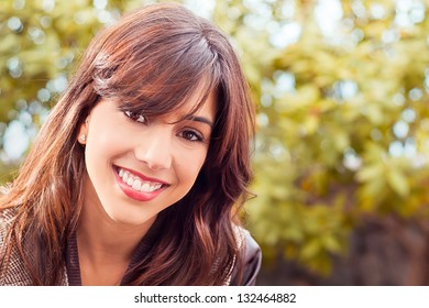 Das Nahaufnahme-Portrait der jungen Frau im Park lächelt hervor