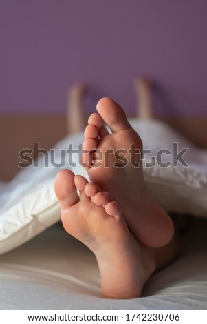 Young woman's feet in bed, close-up.