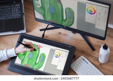 Young woman's hand drawing on a digital tablet. Female graphic designer working from home. Girl's hand drawing on a digital drawing board view from above - Powered by Shutterstock