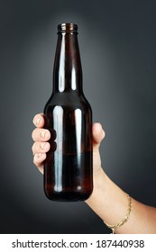 Young Woman's Hand Holding A Full Beer Bottle