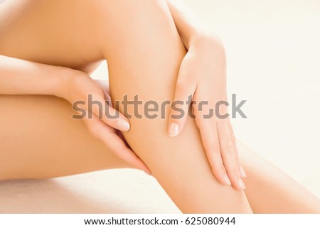 Young woman's hands applying a foot moisturizing cream. Smooth skin.