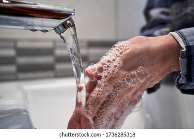Young woman's hands being cleaned with soap and water to avoid contagion of the corona virus. Concept of pandemic and lock down. Close-up. - Shutterstock ID 1736285318