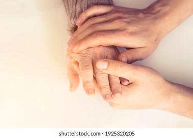 Young Woman's Hands Hold Grandmother's Hands, An Elderly Patient. Handshake, Caring, Trust And Support. Medicine, Family And Healthcare.