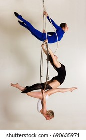 Young woman`s trio doing some acrobatic tricks on aerial luster
