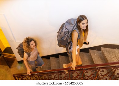 Young Women With Backpacks Arriving To A Youth Hostel 