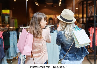 Young Women Buy Clothes In Front Of A Fashion Shop In Shopping Mall