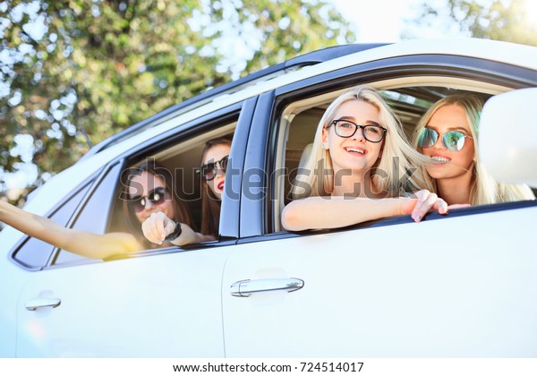 The young women in the car\
smiling