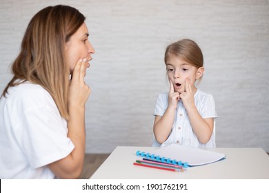 Young women with child make speech therapy exercises at home.