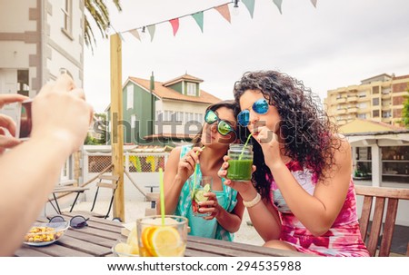 Young women couple drinking healthy drinks outdoors