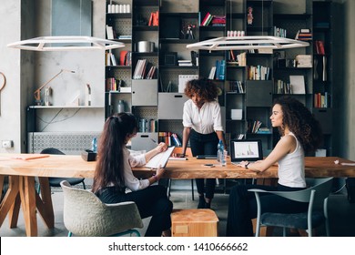Young women discussing project in coworking space – creativity, resourceful, cooperation - Shutterstock ID 1410666662