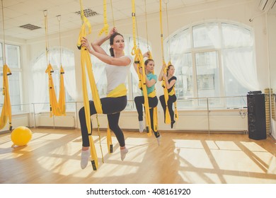Young women doing fly yoga exercises