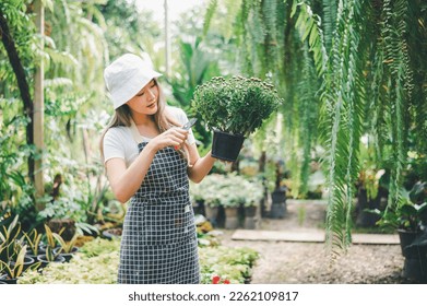 Young women doing hobbies taking care of plants, watering, shoveling flowers. In the garden during the break from work - Shutterstock ID 2262109817