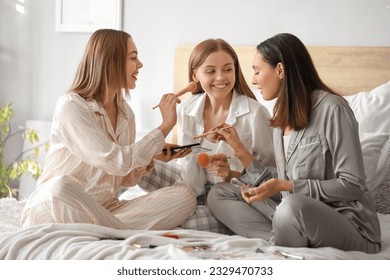 Young women doing makeup in bedroom - Powered by Shutterstock