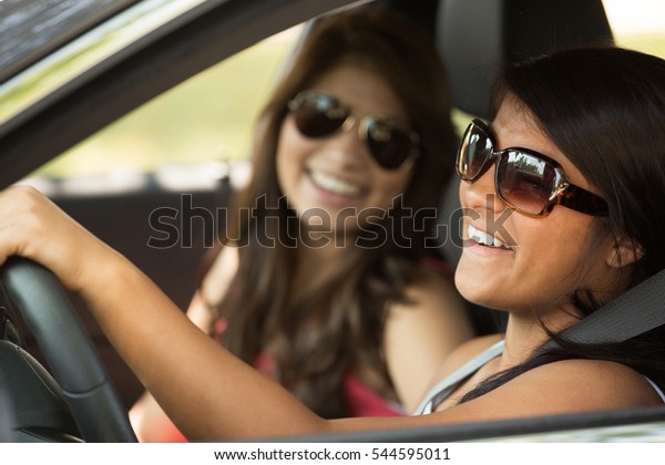 Young women\
driving. Teenage friends driving a\
car.