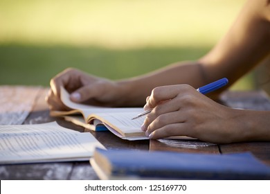 Young Women And Education, Close Up Of Hands Of Girl Studying For College Exam In Park. Side View, Copy Space