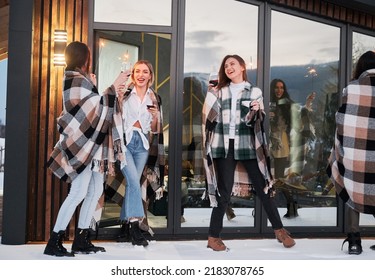 Young Women Enjoying Winter Weekends On Terrace Of Contemporary Barnhouse. Four Girls In Plaids Drinking Wine And Celebrating With Sparklers In The Evening.