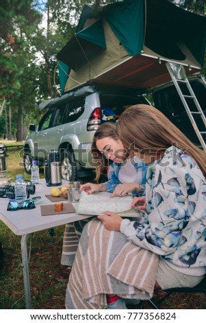 Image, Stock Photo Young women looking road map with vehicle on background