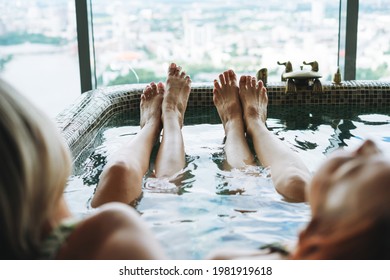 Young Women Friends Take Bath In Spa Hotel In Front Of Panoramic Window, Treat Yourself