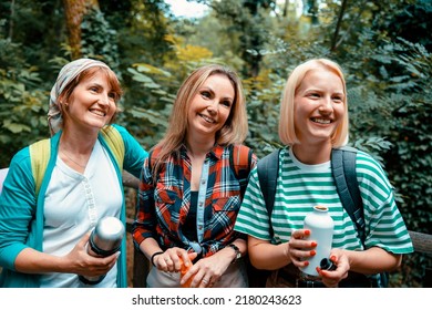 Young Women friends in the woods. Smiling diverse females on hiking break in forest. Waist up portrait, close up