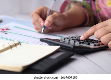 Young Women Hand Use Calculator And Notepad On Desk