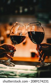 Young Women Hands Holding Glasses Of Red Wine And Clinking Wine Glasses In Cafe Or Restaurant