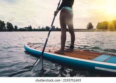 Young women Having Fun Stand Up Paddling in blue water sea. SUP. girl Training on Paddle Board. selective focus - Powered by Shutterstock