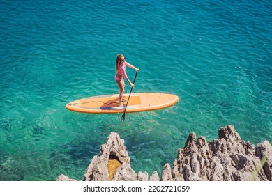 Young women Having Fun Stand Up Paddling in blue water sea in Montenegro. SUP. girl Training on Paddle Board near the rocks Portrait of a disgruntled girl sitting at a cafe table - Powered by Shutterstock