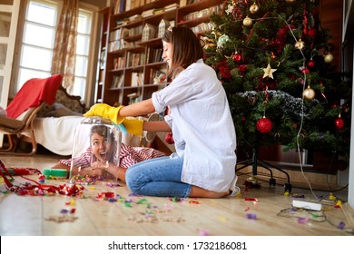 Young Women Having Fun While Cleaning House After Christmas Holiday