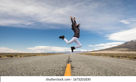 A young women jumping on a road - Shutterstock ID 1673201830