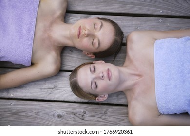 Young Women Laying On Deck With Eyes Closed