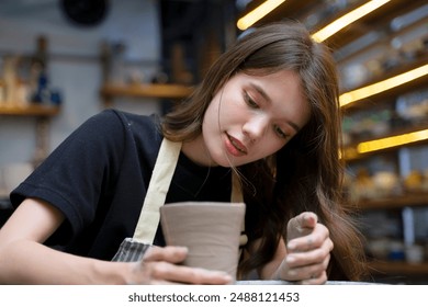 Young women is making earthenware at workshop. Small business and hand craft product. - Powered by Shutterstock