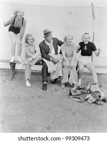 Young Women And A Man Watching A Baseball Game With Enthusiasm