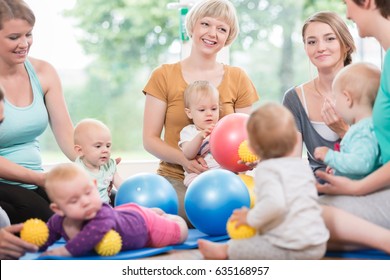 Young women in mother and child group playing with their baby kids