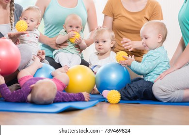 Young women in mother and child group playing with their baby kids