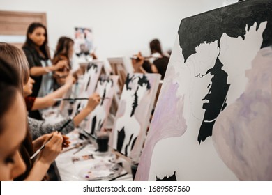 Young Women Paint With Brushes On Easels In Art Class. Art School, Creativity And People Concept