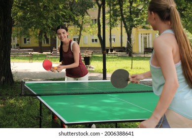 Young Women Playing Ping Pong In Park