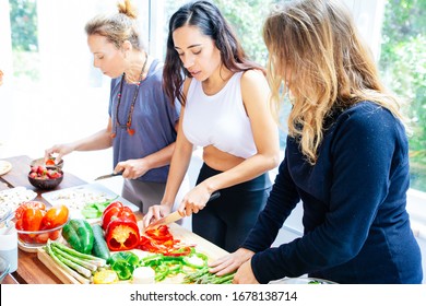 Young Women Preparing Food. Fit Young Women In Sportswear Standing Near Table And Cooking Healthy Meal With Fresh Vegetables And Fruits. Healthy Eating Concept