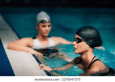 Young Women Resting, Poolside, Indoor Pool. Recreational Swimming. - Powered by Shutterstock